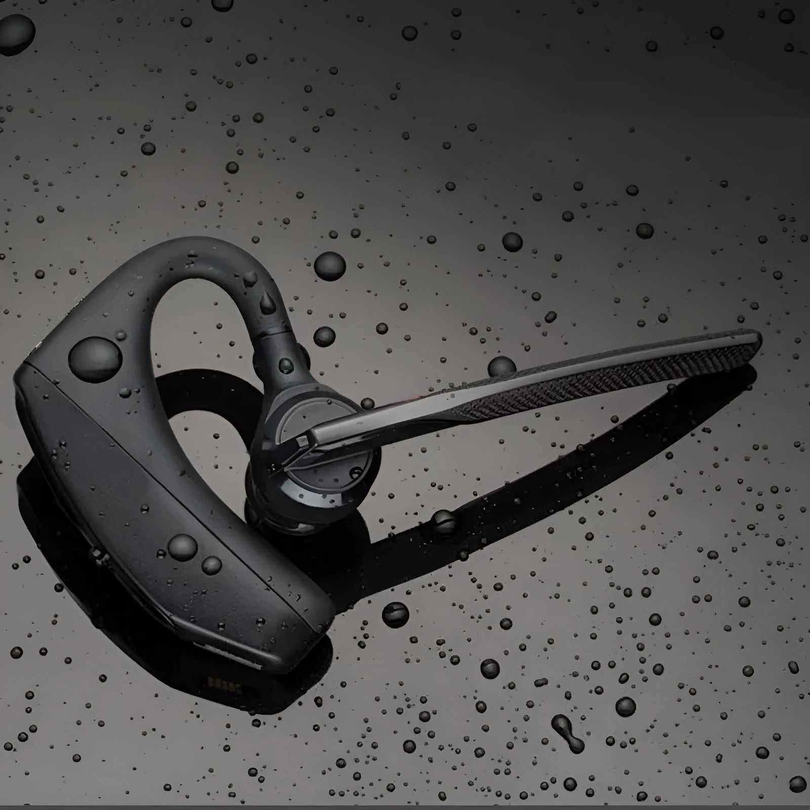 Black wireless sports headphones with a large battery and built-in microphone on a plain background.