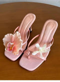 Women's handmade asymmetric floral high heel sandal in calf leather on a white background.