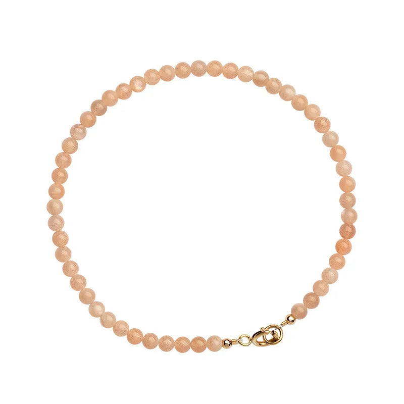 Close-up of a women's bracelet with small 3mm round sunstone beads on a string.