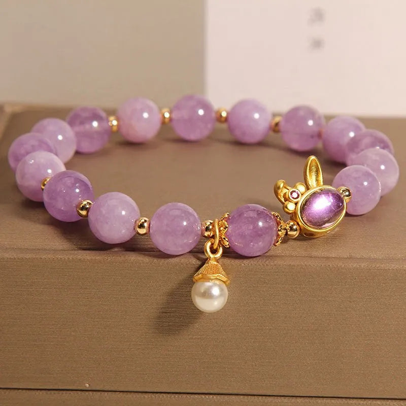 Purplish red mauve jade rabbit head charm on a crystal adjustable Mori-style bracelet.