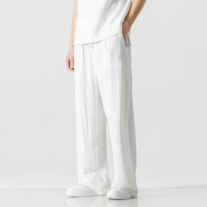 Men's beige cropped linen trousers with a drawstring waist and straight-leg casual style on a hanger.