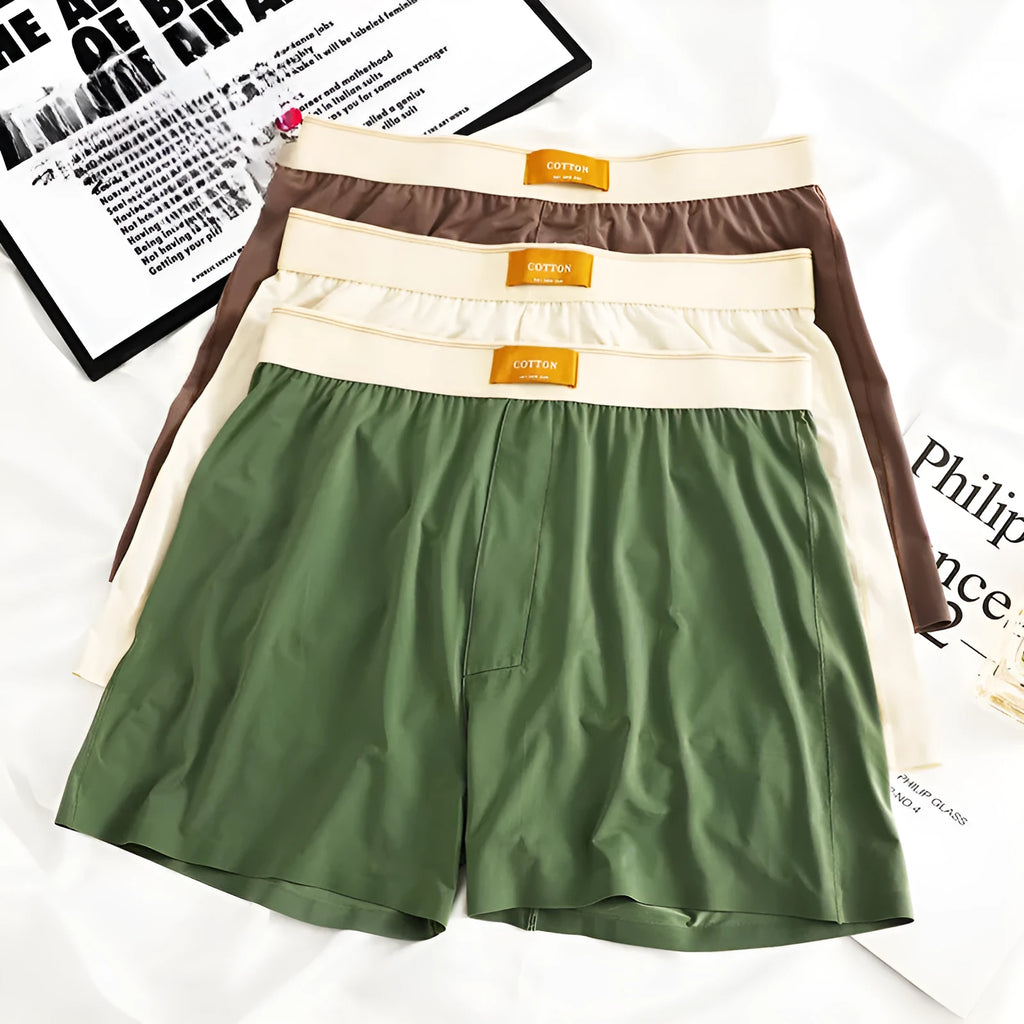 Pack of three men's solid colour ice silk boxer shorts laid flat.