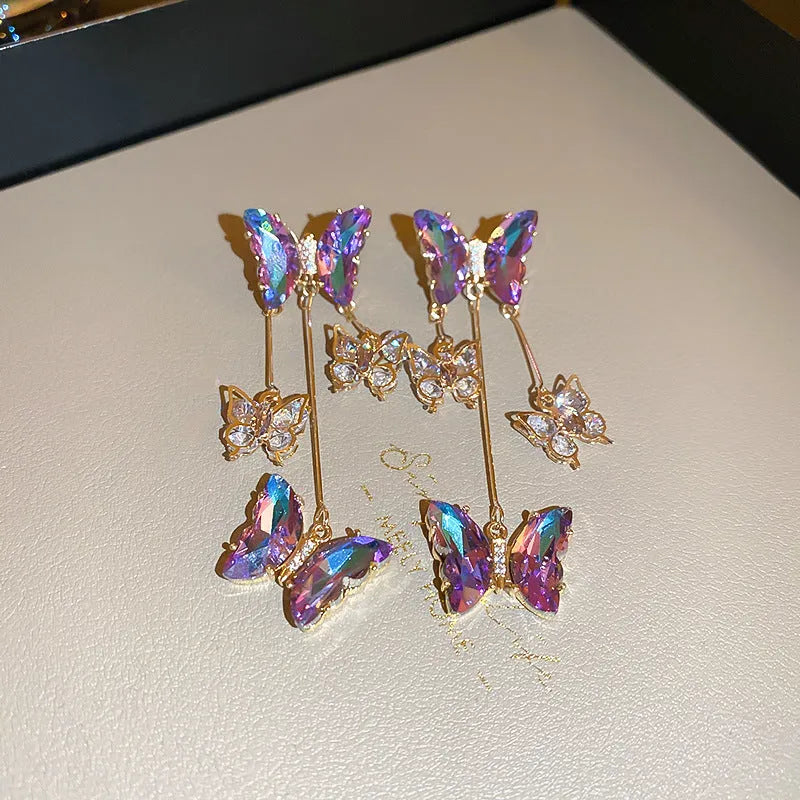A pair of silver needle blue purple butterfly tassel earrings with crystal flowers on an alloy base.