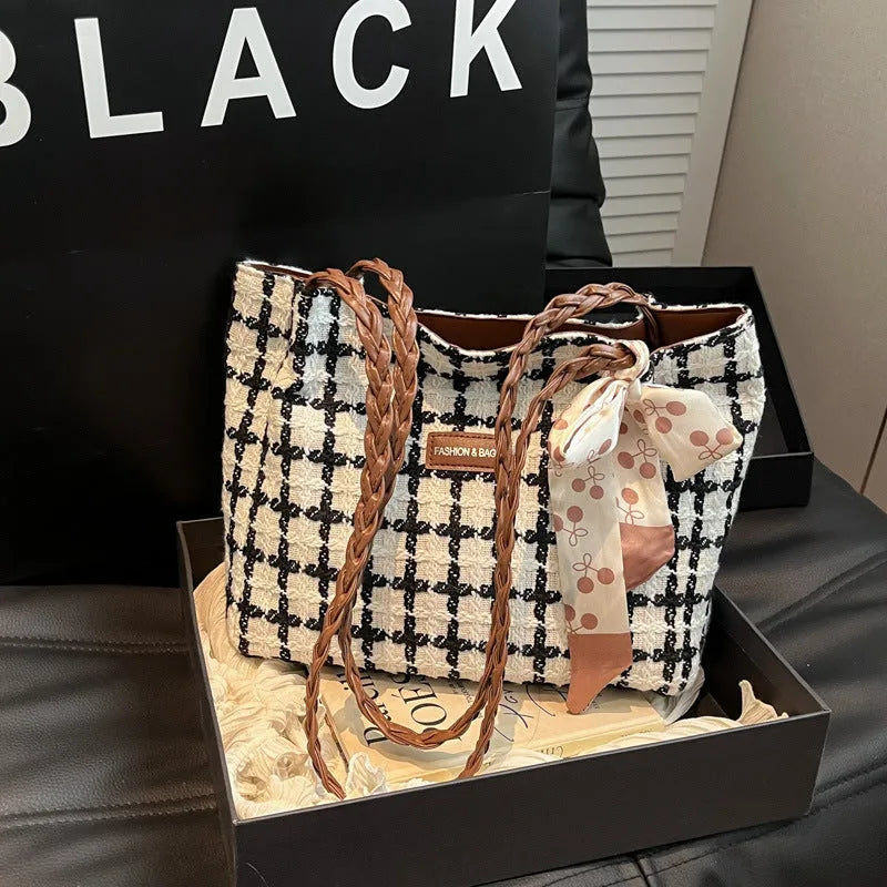 A black woven wool horizontal square shoulder bag showing external sandwich pocket and internal organiser compartments.