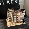A black woven wool horizontal square shoulder bag showing external sandwich pocket and internal organiser compartments.