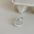 Geometric open ring with three-dimensional interlaced matte metal construction in gold or silver finish