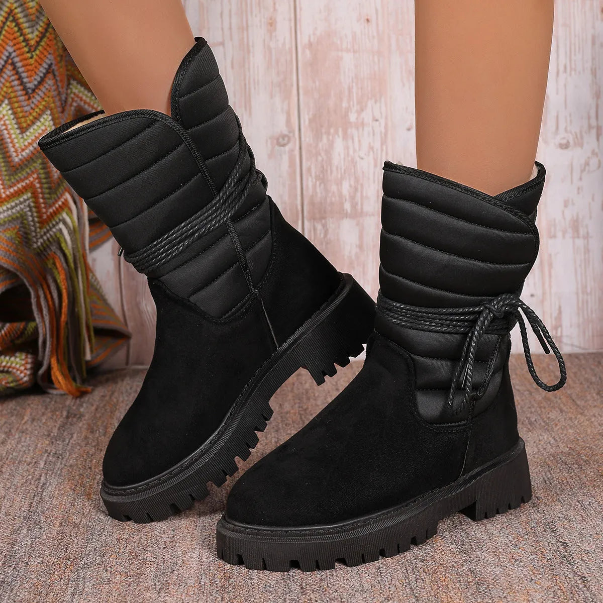 Women's chunky heel snow boots in suede with lace-up design and fleece lining, shown in black.
