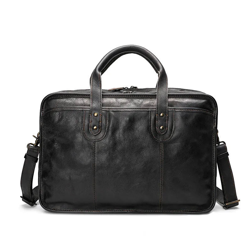 Brown vintage leather men's briefcase open to show internal laptop pocket and document organisers.