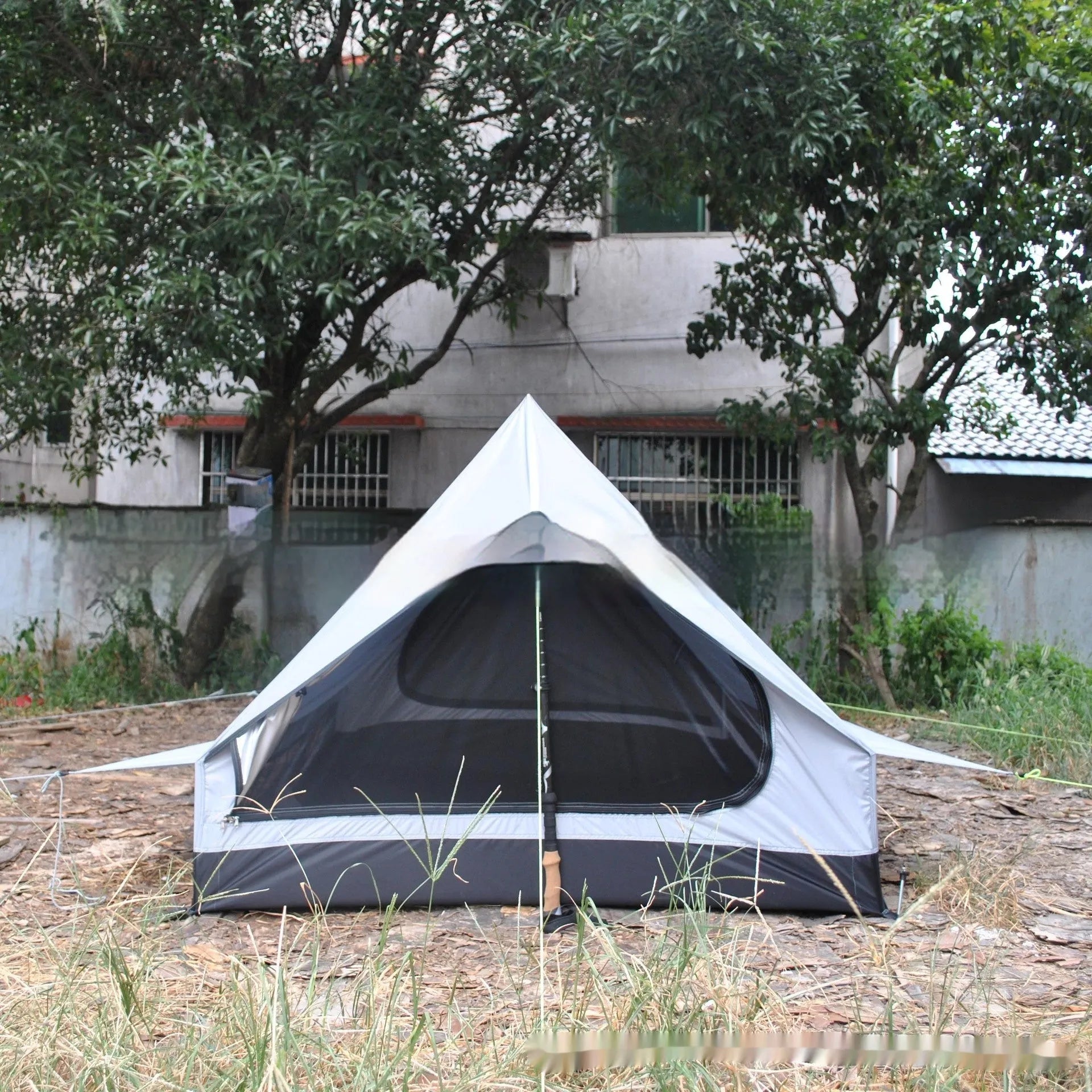 Brown A-line hiking tent erected with hiking poles showing spacious interior for 2-3 people