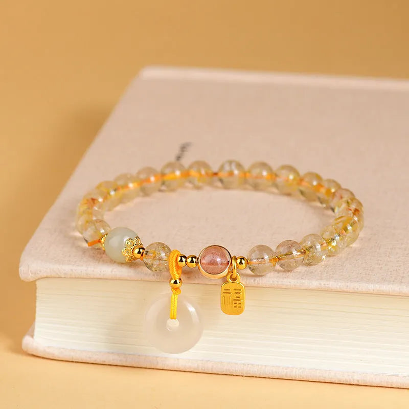 Gold rutilated quartz crystal bracelet with safety buckle closure and geometric pendant