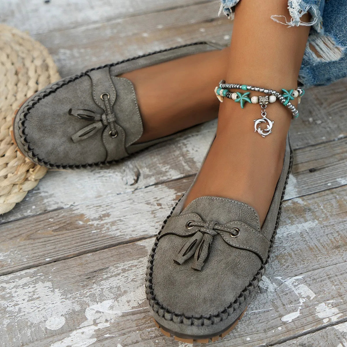 Women's suede casual flat shoes with a bow detail in pink, shown from the side.