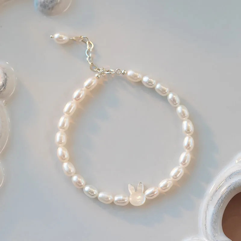 White shell bead bracelet with silver rabbit charm on elastic string