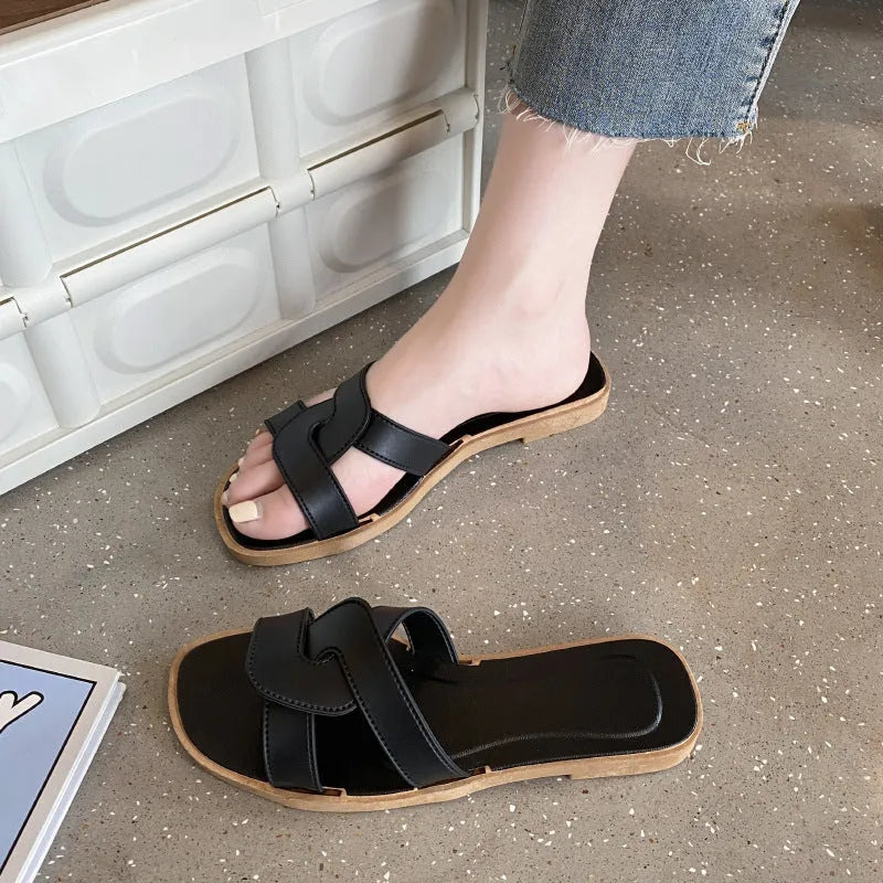 Women's PVC flip flop slippers with a cross strap and toe ring in a solid colour.
