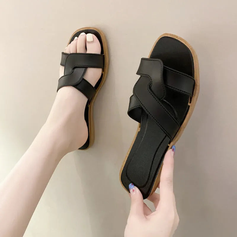 Women's PVC flip flop slippers with a cross strap and toe ring in a solid colour.