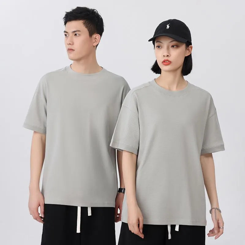 Man wearing a light grey pique cotton short sleeve t-shirt with a loose fit.