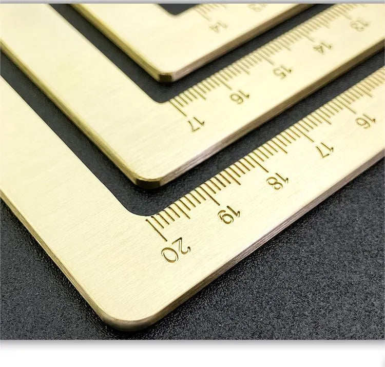Solid brass calligraphy paper weight with engraved design on a wooden desk.