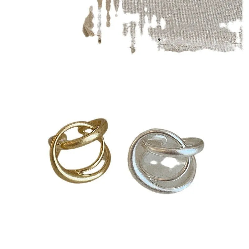 Geometric open ring with three-dimensional interlaced matte metal construction in gold or silver finish