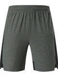 Man wearing forest green spandex five-point casual shorts, showing mid-waist fit and shorts length.