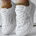 Women's white canvas sports running shoes with flat heel and round toe on a plain background.