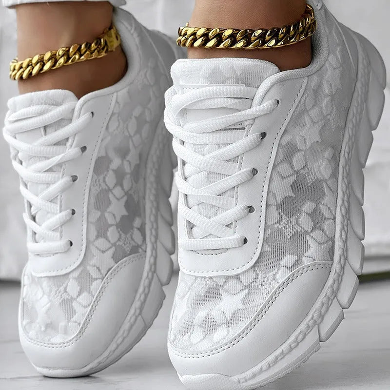 Women's white canvas sports running shoes with flat heel and round toe on a plain background.