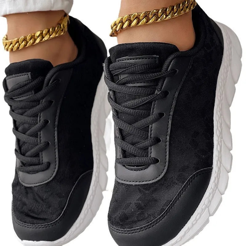 Women's white canvas sports running shoes with flat heel and round toe on a plain background.