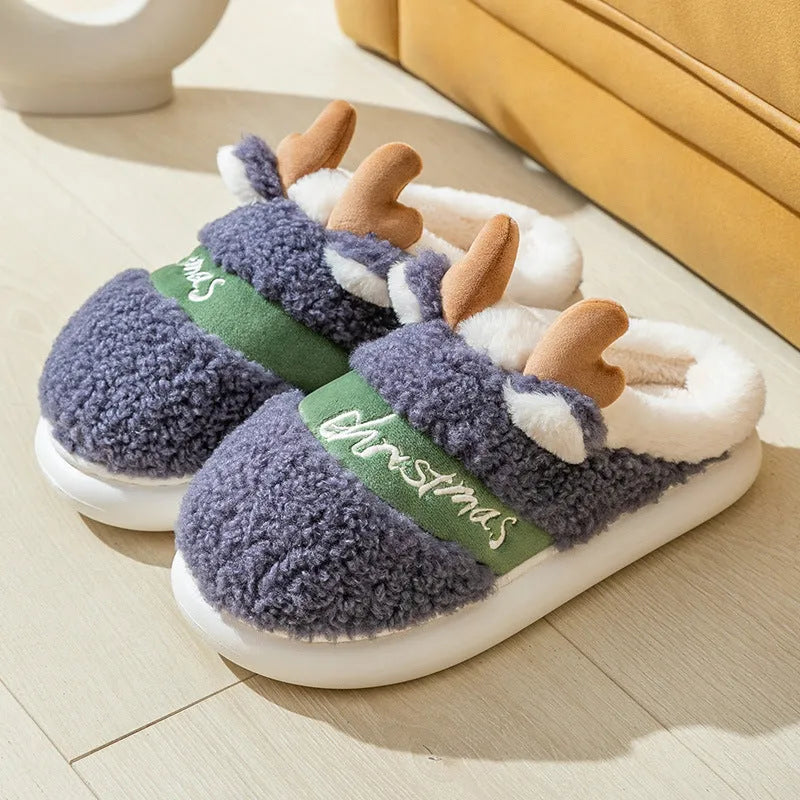 Pair of Christmas elk winter home slippers with suede upper and candy-coloured antler print on bedroom floor