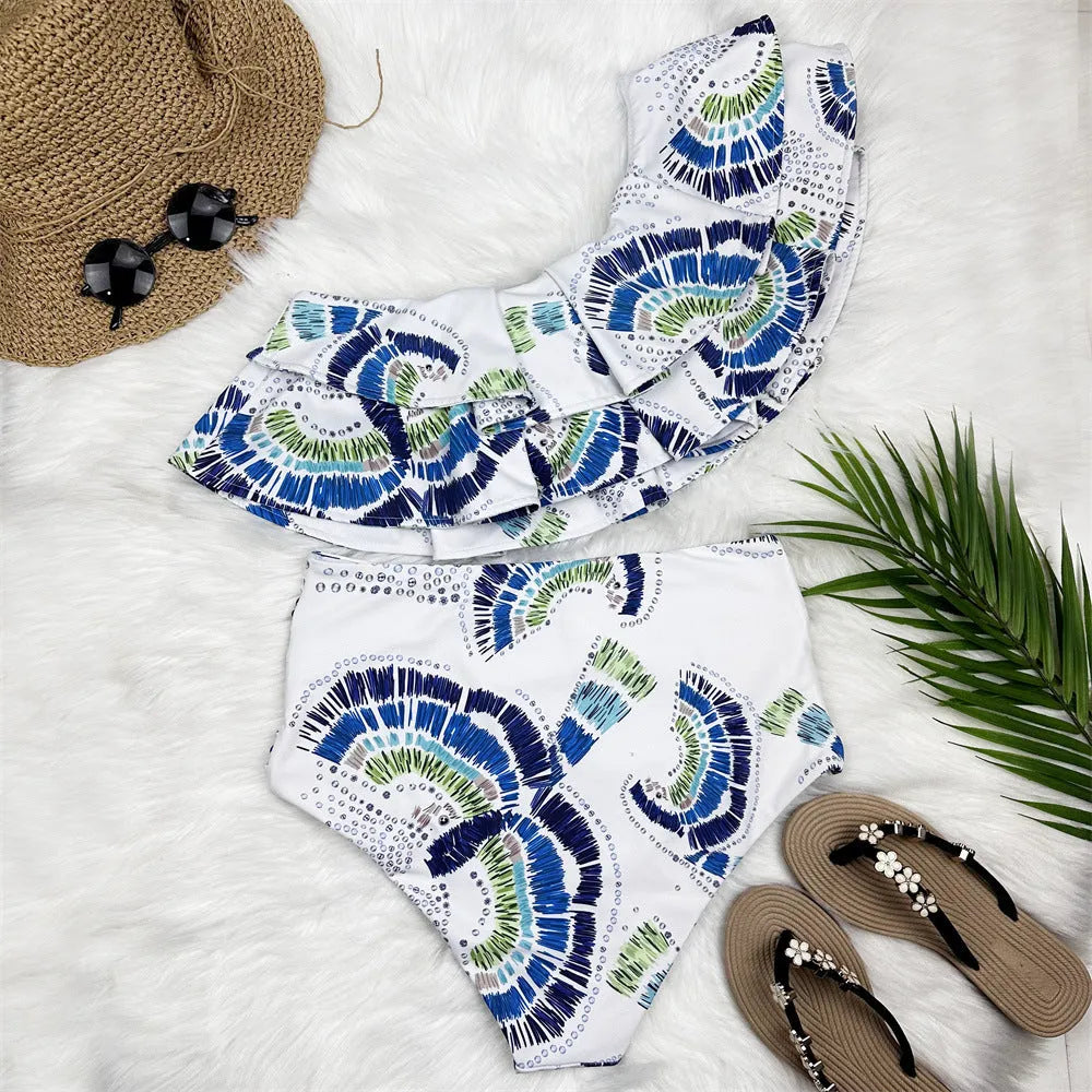 White women's one-shoulder bikini with lotus leaf detail and high-leg split bottom.