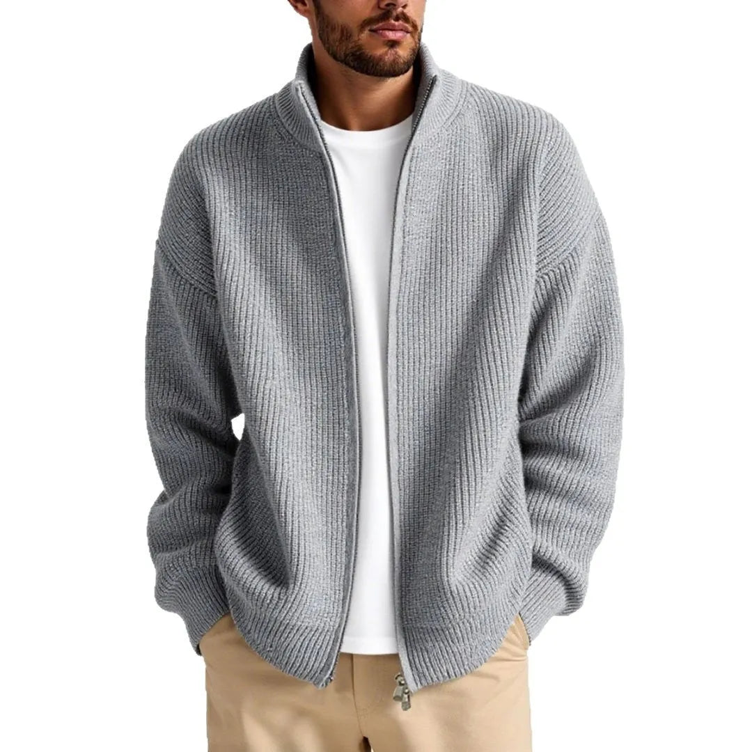 Man wearing a loose-fit grey cardigan sweater coat, showing the relaxed silhouette and knit texture.