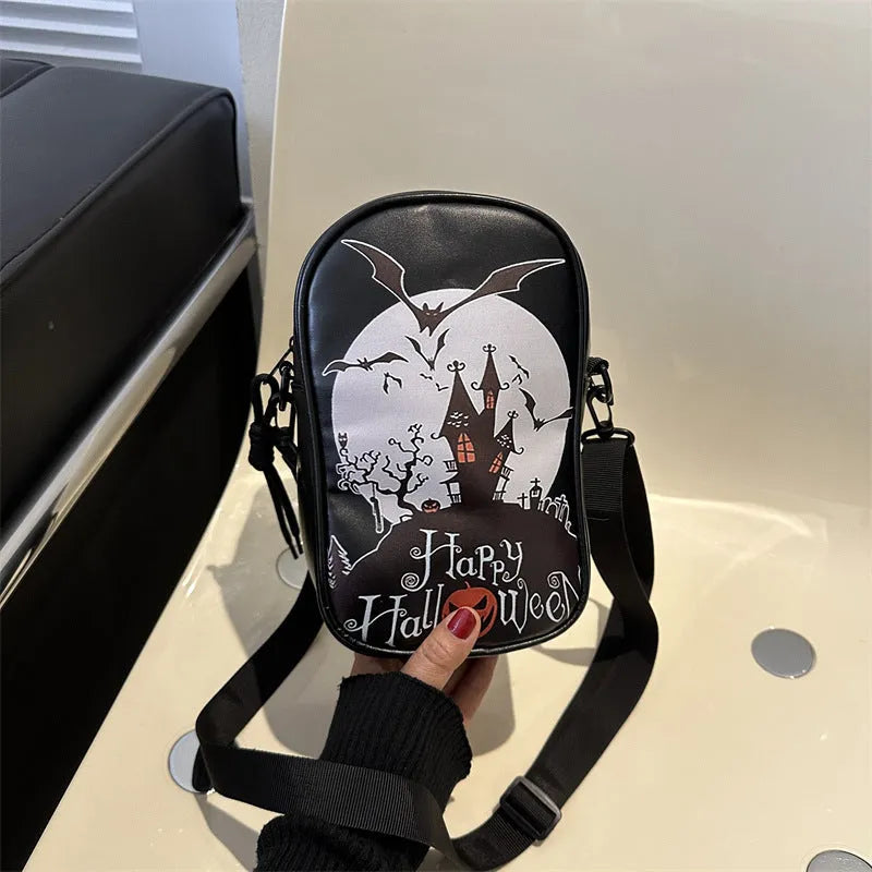 Black Halloween crossbody bag with graffiti print of cartoon pumpkins, ghosts, and bats.