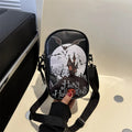 Black Halloween crossbody bag with graffiti print of cartoon pumpkins, ghosts, and bats.