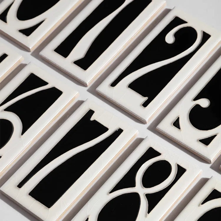 Handmade retro-style ceramic doorplate with white enamel number on a blue glazed background.