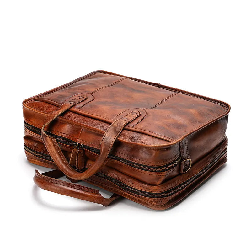 Brown vintage leather men's briefcase open to show internal laptop pocket and document organisers.