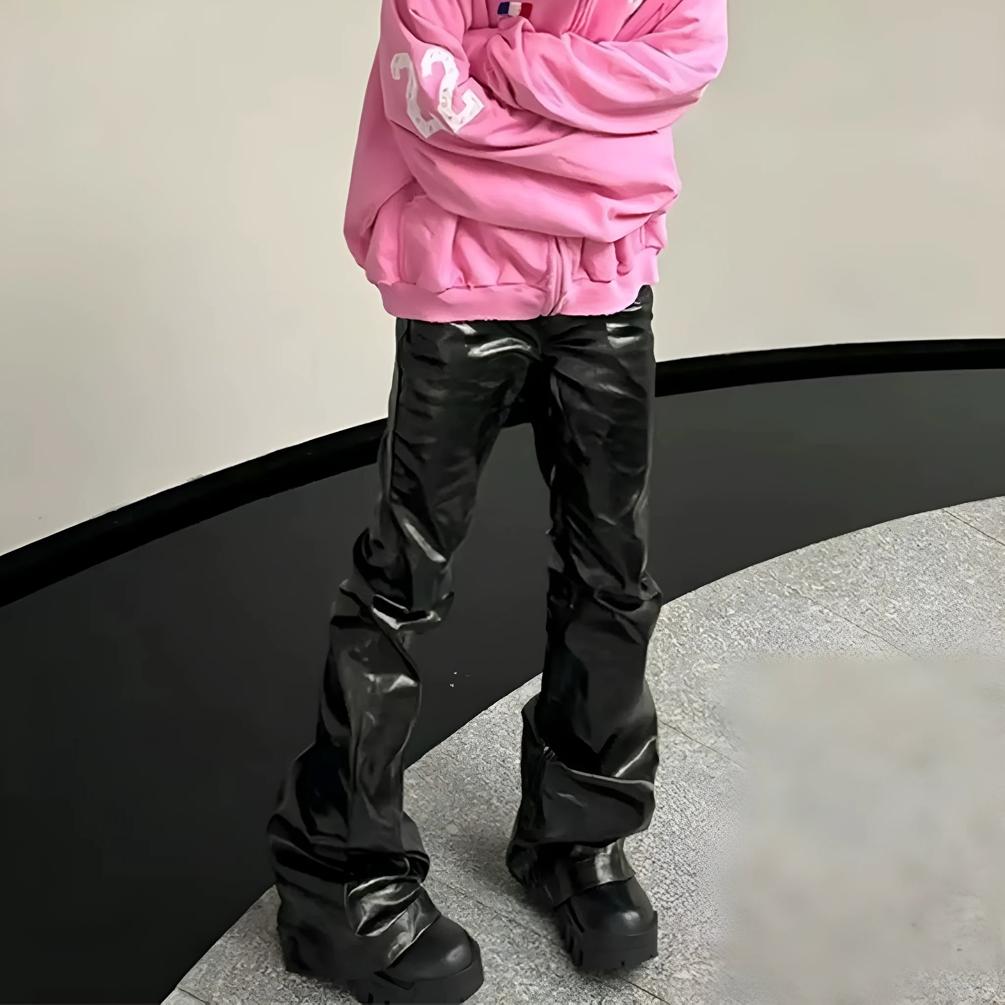 Black coated patent leather skinny jeans with a straight leg and mid-waist fit on a model.