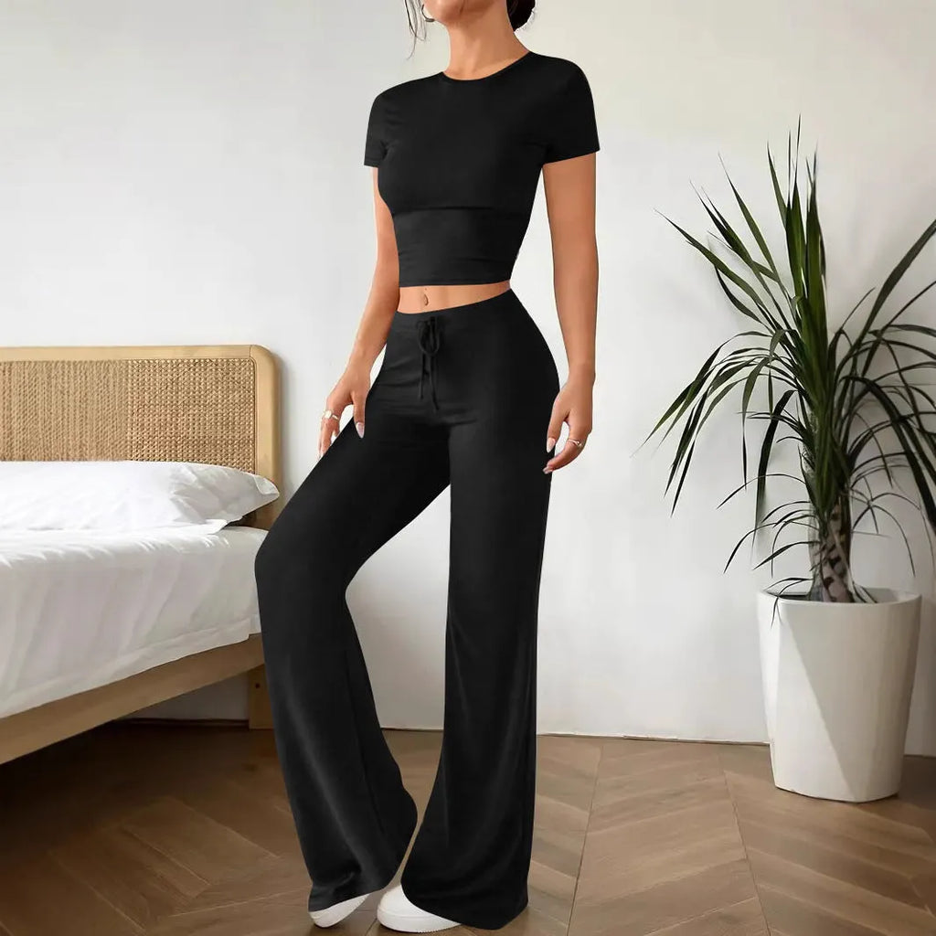 Black women's polyester tracksuit set with short sleeve top and high-waist trousers.
