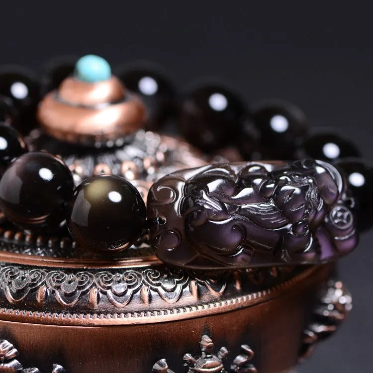 Polished crystal Pi Xiu bracelet with geometric ice stone beads on a wrist.