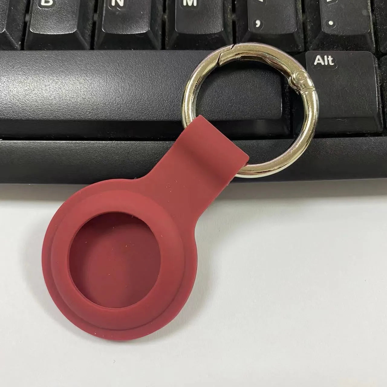 Silicone protective case for Apple AirTag with metal snap button in assorted colours on a keyring.