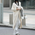 Long grey knitted hooded trench coat cardigan on a hanger, showing loose fit and long sleeves.