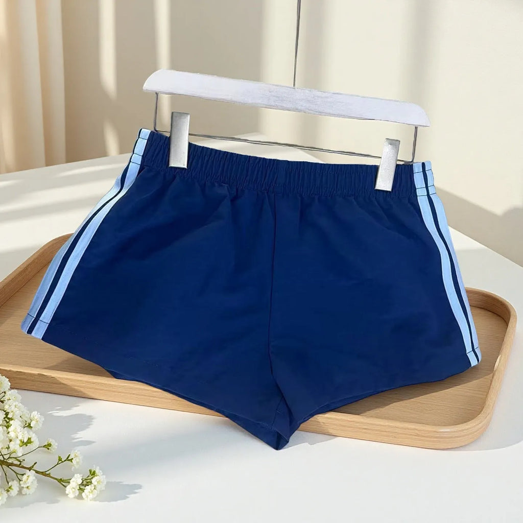 Men's navy blue high-waist nylon sports shorts laid flat, showing casual style and micro-elastic fabric.