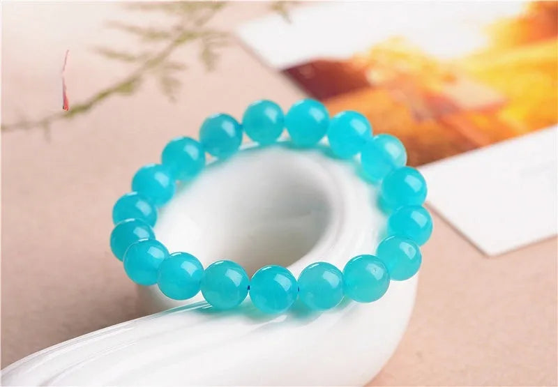 Natural blue-green Amazonite 7A grade scattered beads bracelet on a white background.