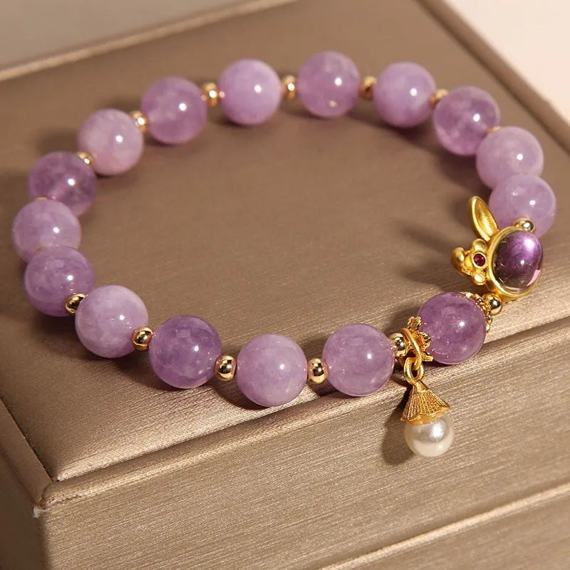 Purplish red mauve jade rabbit head charm on a crystal adjustable Mori-style bracelet.