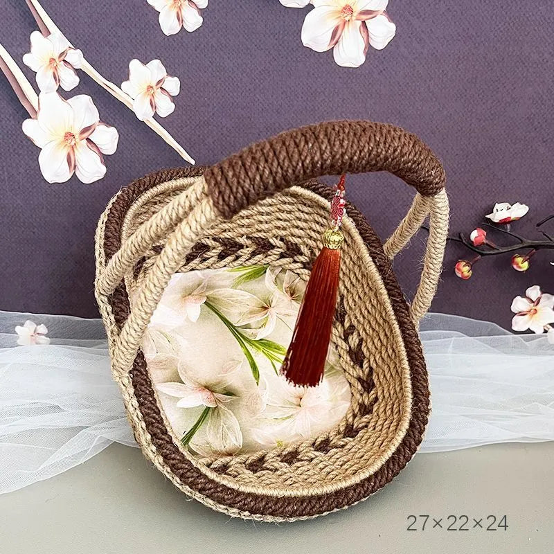 Hand-woven straw basket with hemp rope binding in coffee brown colour, 19cm long by 12cm wide.