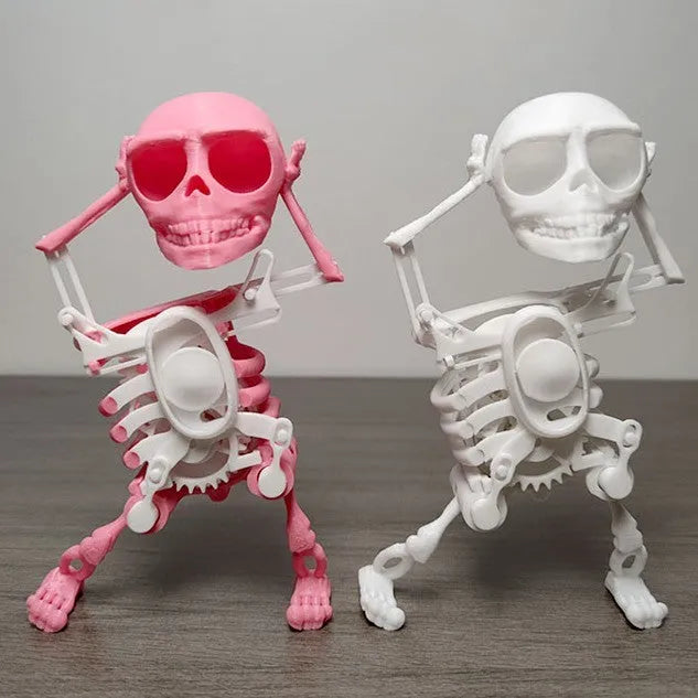 3D printed dancing skeleton gravity toy in pink and white, 22cm tall, on a desk