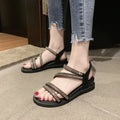 Gold women's flat sandals with rhinestone decoration and elastic band, on a rubber sole.
