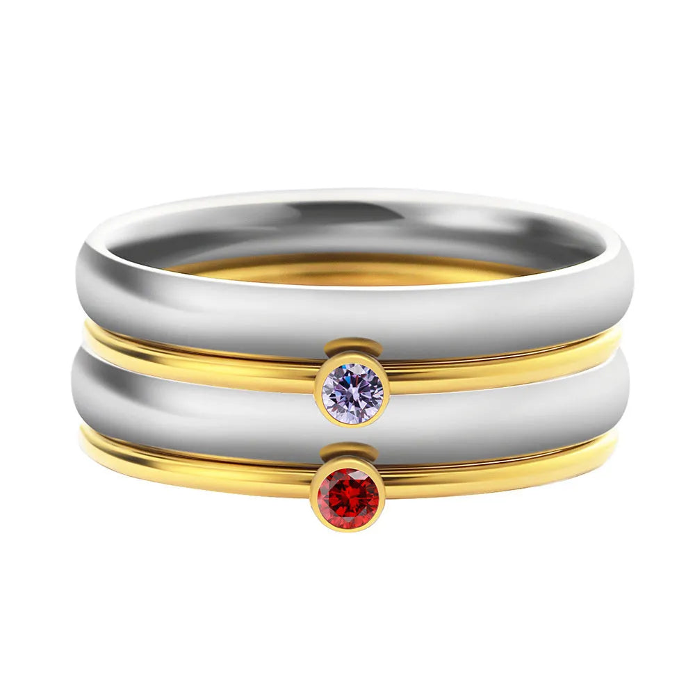A geometric engraved titanium steel ring with a December birthstone, showcasing gold-tone and steel lettering accents.