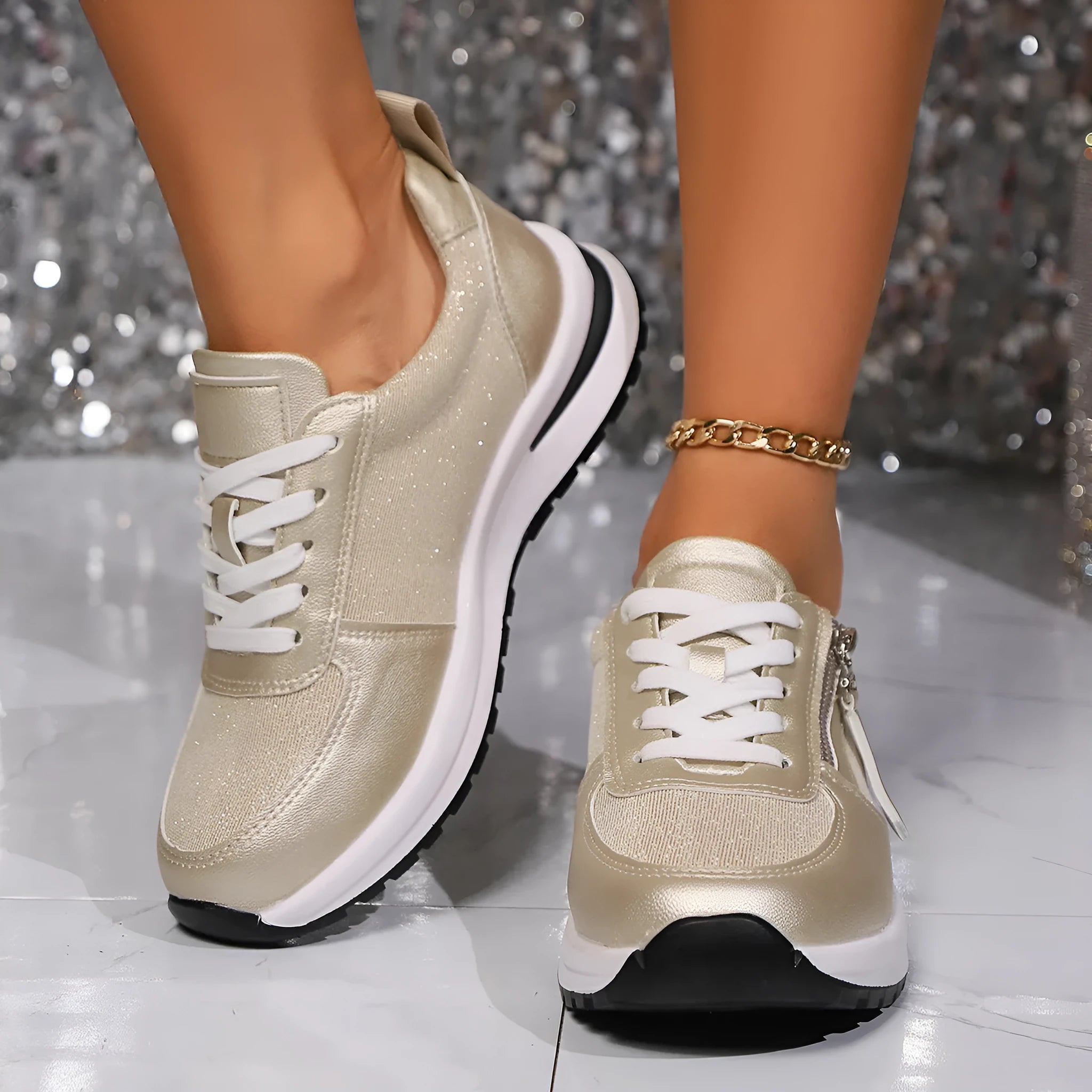 Gold women's lace-up pumps with round toe and flat rubber sole on a white background.
