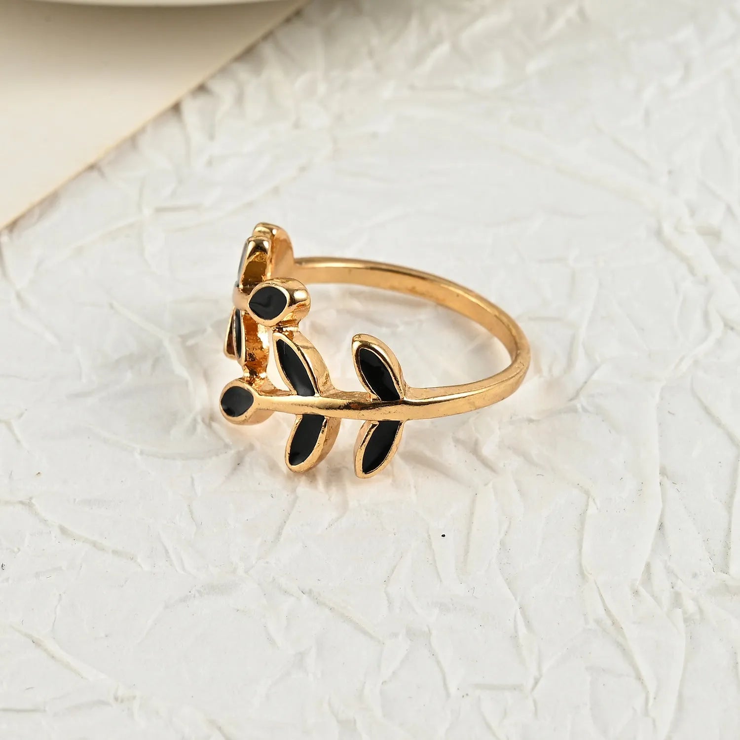 Gold geometric leaf acrylic ring for women on an index finger.