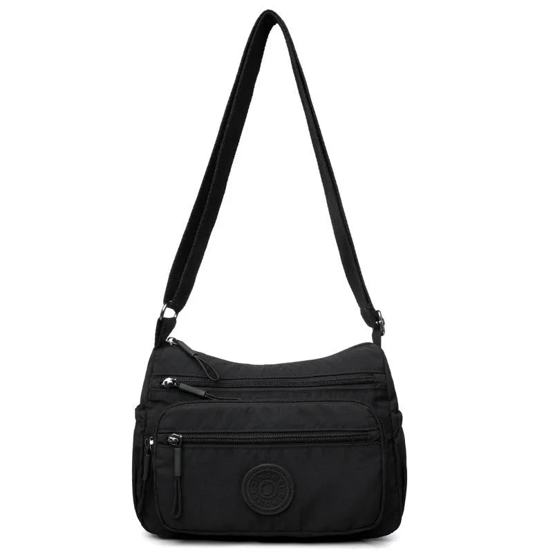 Water-repellent nylon crossbody bag with three-dimensional pockets in grey, black or red options