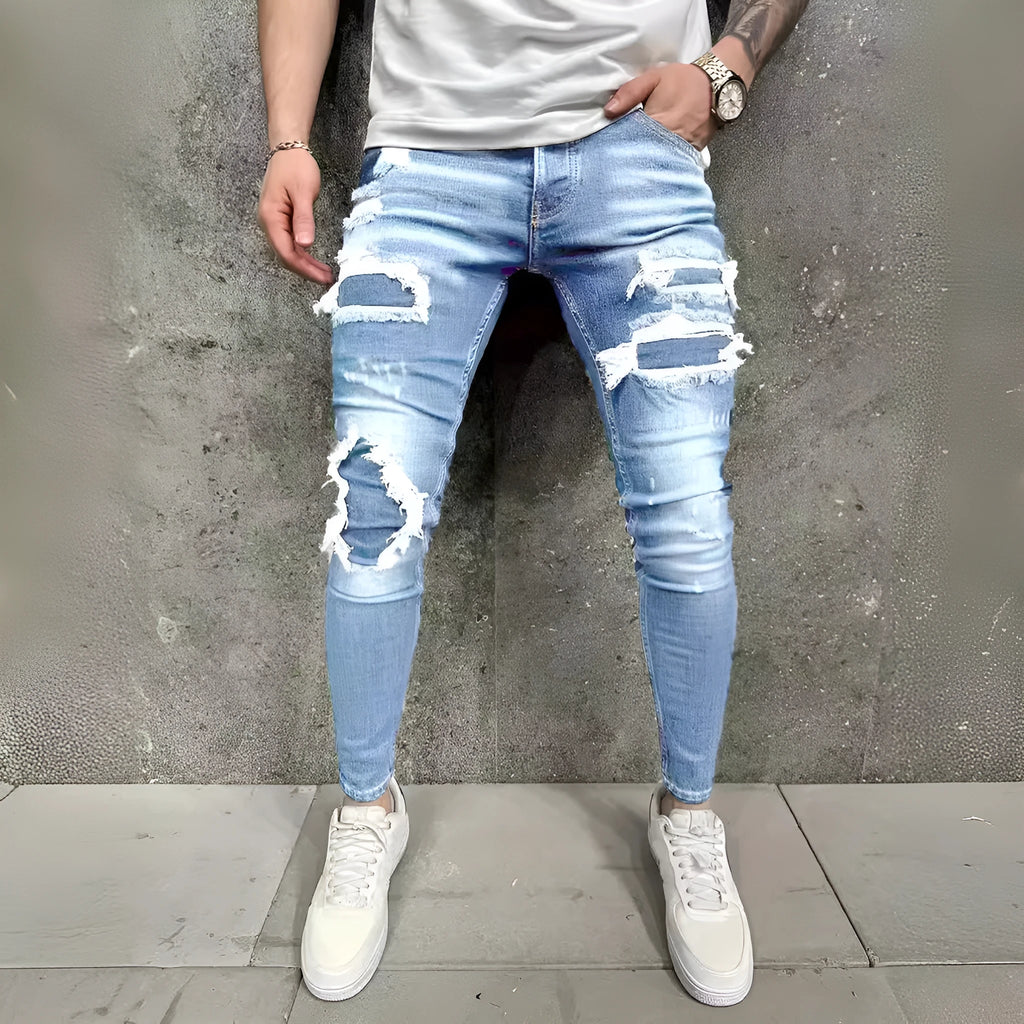 Men's denim jeans with worn-out patch detail in light blue, mid-waist tight fit British style