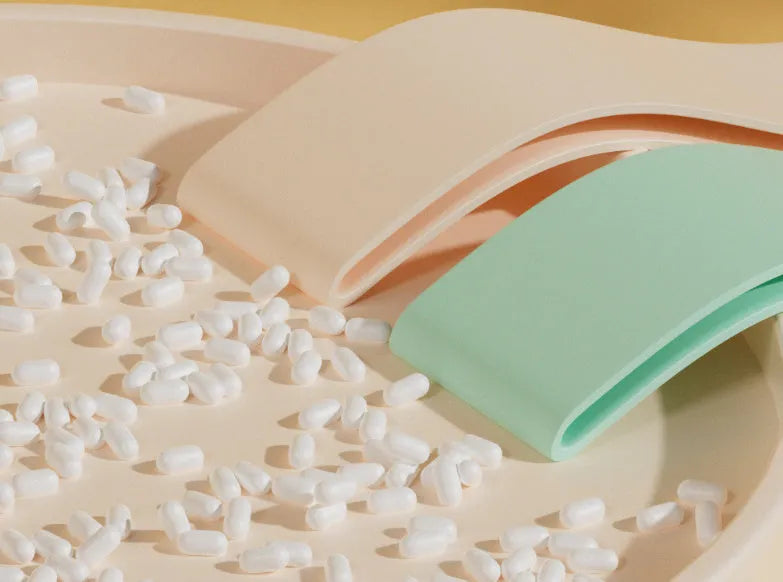 Set of four colour-coded plastic resistance bands for fitness: pink, orange, beige, and green.
