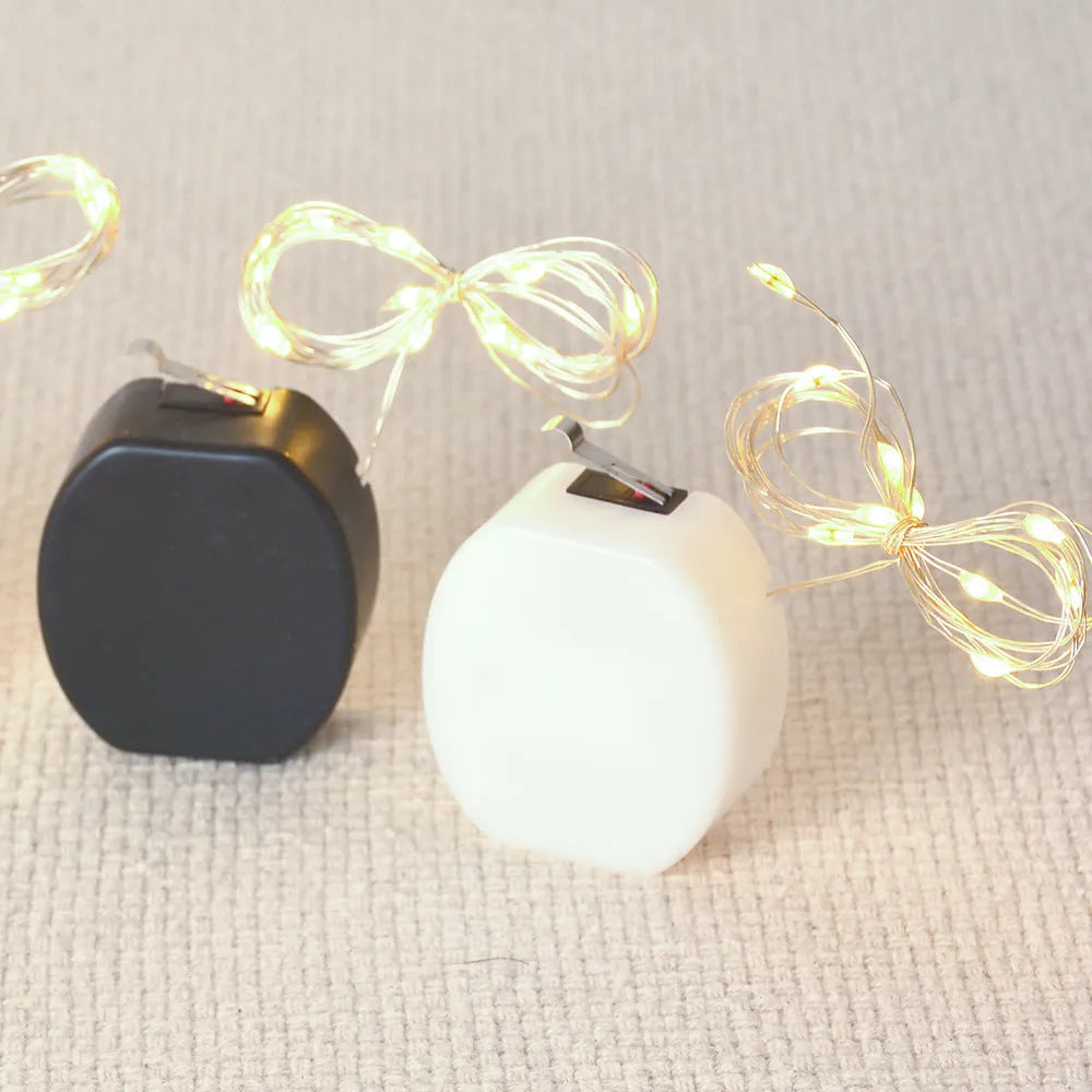 Copper wire LED fairy light string with 20 small button lights and a white plastic battery box.